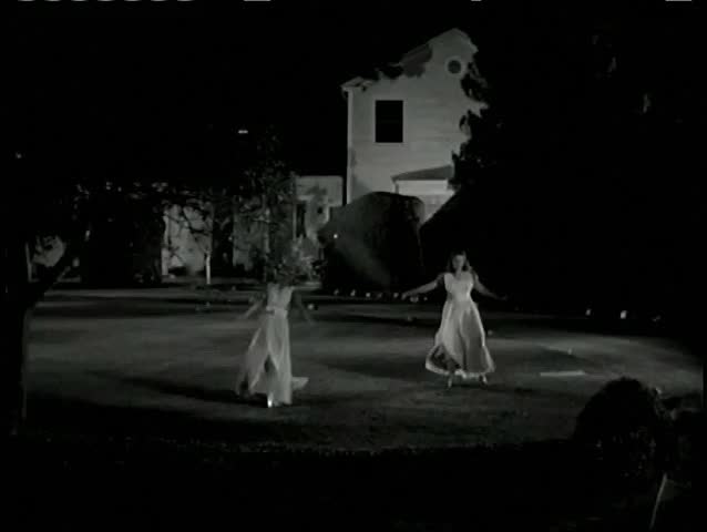 Wide shot women doing cartwheels in backyard