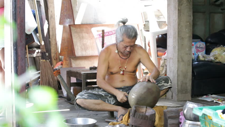 BANGKOK - NOVEMBER 12: A man shapes an alms bowl in Bangkok, Thailand on November 12, 2011. Alms bowls are used by monks during their morning processions.
