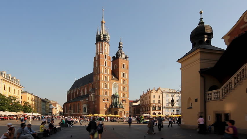 KRAKOW, POLAND: CIRCA 2011: Tourists at Main Market Square close to St Mary's Basilica on a hot summer day