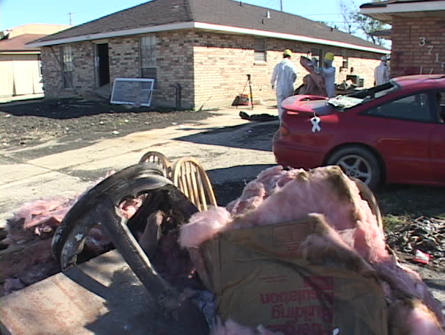 Relief workers clean up destroyed houses after Hurricane Katrina.