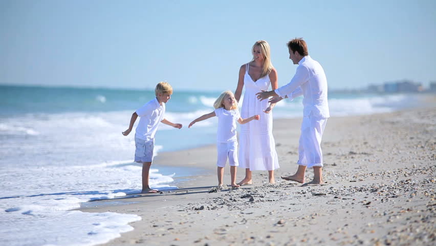 Attractive young parents having fun with their children on the beach