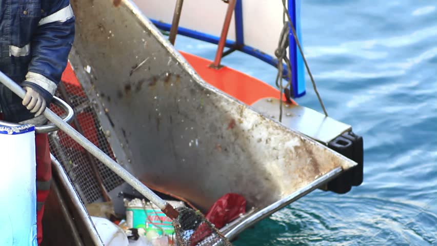 Scoop being used to collect trash from the water 