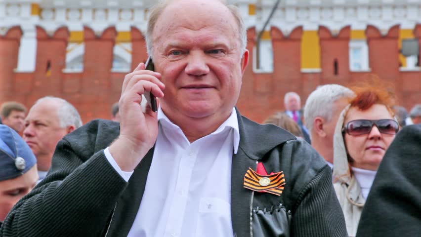 MOSCOW - MAY 9: G. Zyuganov leader of Communist Party of Russia with cell phone at background of Kremlin wall on May 9, 2011 in Moscow, Russia
