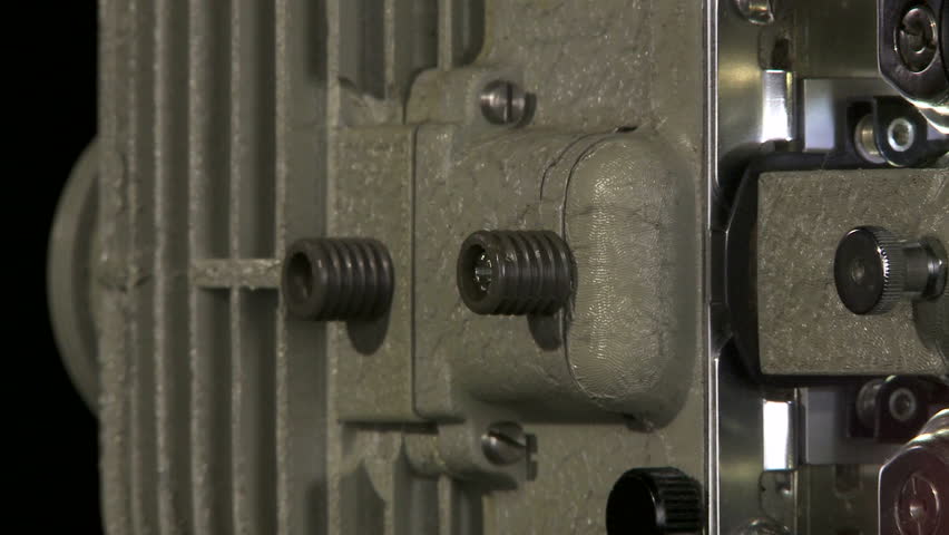 Close up tracking shot of 16mm film projector lens