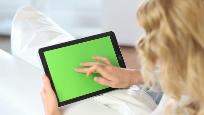 Back view of woman at home using electronic tablet