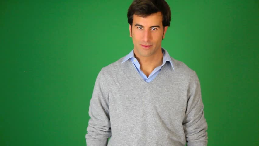 Young man talking to camera on green background