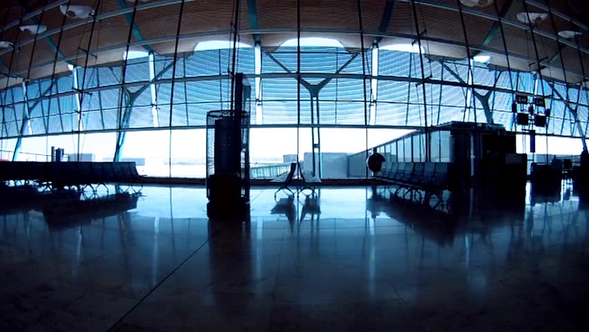 Couple rushing for flight through  empty airport waiting lounge. Camera moving on dolly.