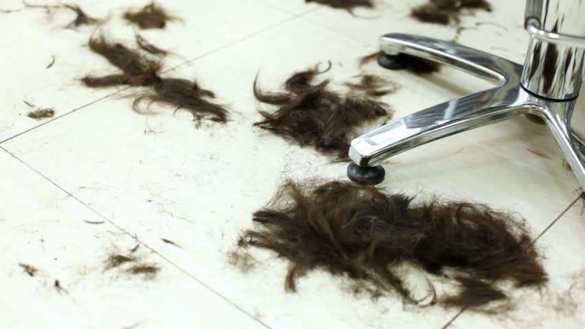 Black hair lie on floor in hairdressing salon after hairstyle