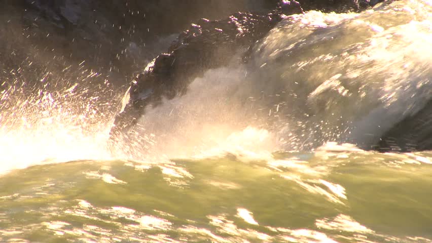 Raging river water cascading down into a torrent and over