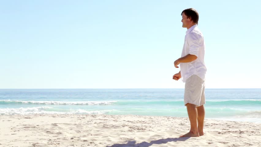 young couple embrace, spin and kiss while outdoors on a tropical beach vacation for honeymoon romance and healthy lifestyle clip