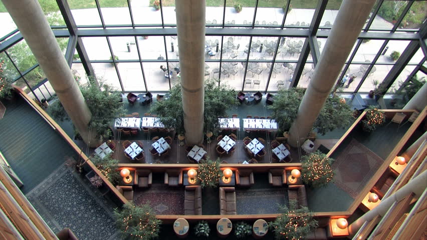 Balconies resort lobby looking down. Restaurant tables and expansive glass windows open to the mountains. Wasatch Mountains, Salt Lake City, Utah. Scenic luxury hotel, timeshare and resort.