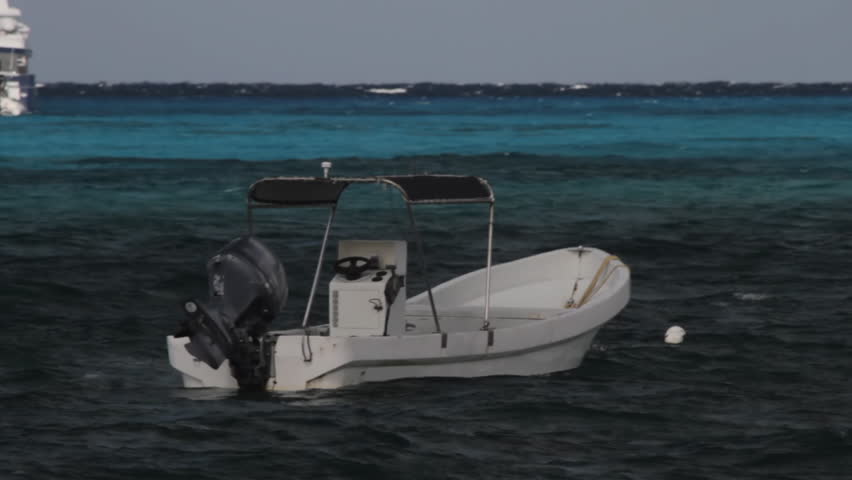 Motorboat in Caribbean Sea (HD). Small motorboat used for transportation floating in the Caribbean sea. Every legend and name on the boat has been rotoscoped frame by frame to erase it.