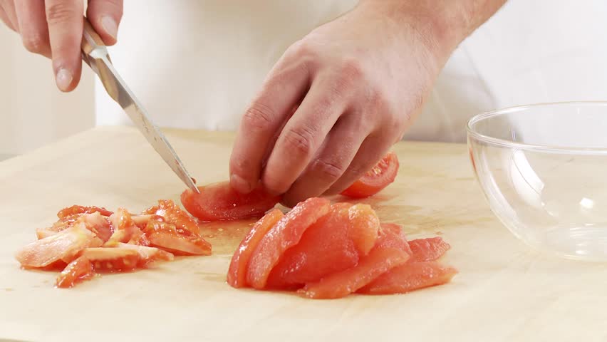 Peeled tomato quarters being deseeded