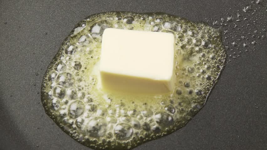 Butter being heated and onion and parsley being fried