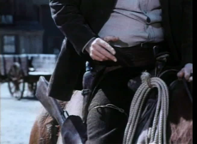 Cowboy slowly moving hand towards holster