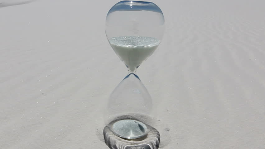 Time Lapse, Sand filters through hourglass resting, reflected on white sand. 1080p   