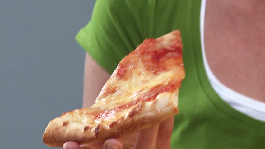 Young woman eating a slice of pizza