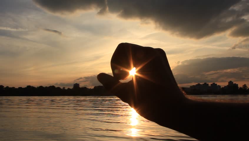 A hand catches the sun