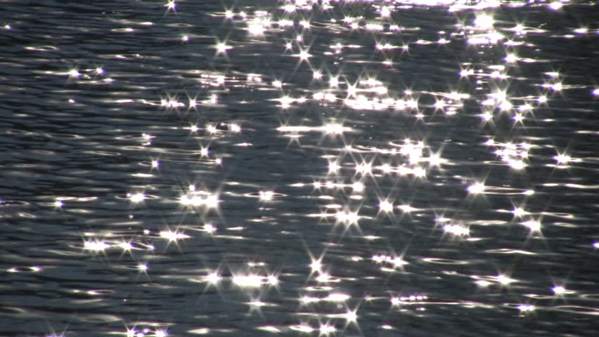 Sunlight reflects and glitters off of the calm water. (High Definition)