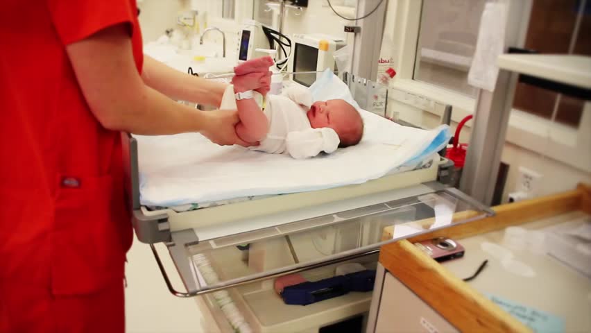 A newborn baby at the hospital with the nursing staff.