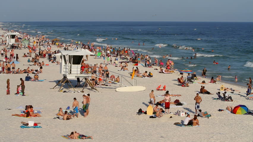 Vacationers relax and sunbath on the beach around lifeguard stands during spring break weekend March 18, 2012 on Pensacola Beach, Florida.