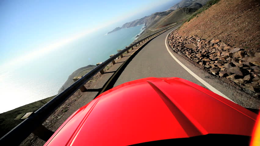 Californian road trip driving a Cabriolet on a winding Pacific highway