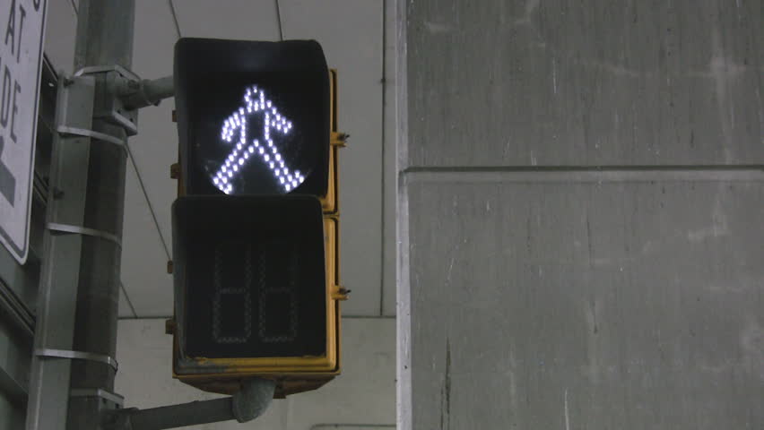A crosswalk signal changes from a 'man' to a 'hand' and counts down from 10 to 1.