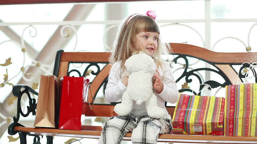 Girl hugging a teddy bear after shopping