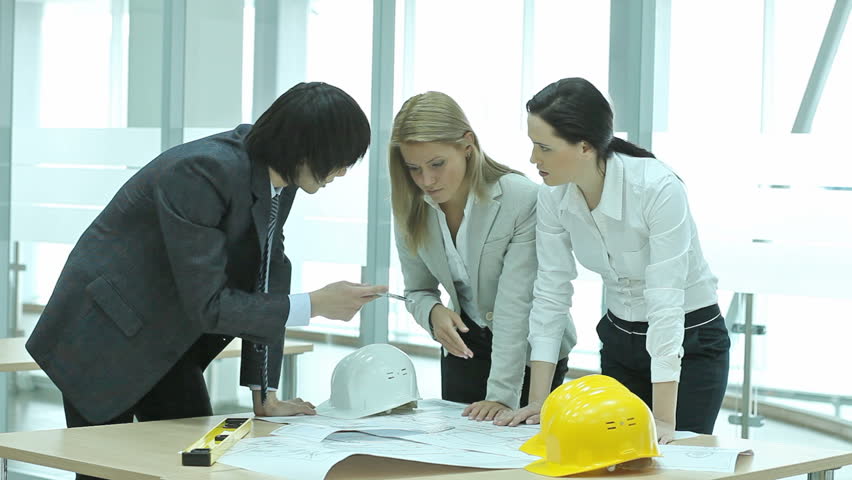 Business team arguing over a blueprint, women looking annoyed