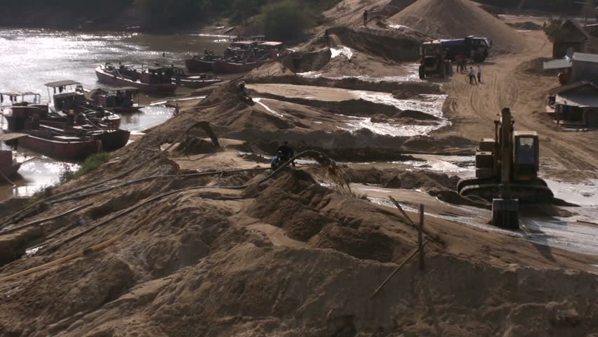 North Vietnamese Boats Barges Unload Dredge River Sand Sand Depot. Dredging is an excavation activity or operation usually carried out at least partly underwater, in shallow seas or fresh water areas.