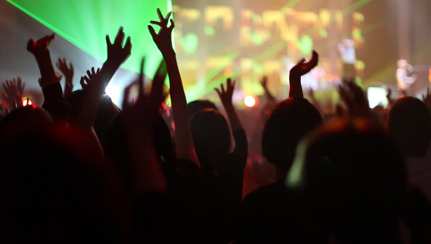 Crowd of people illuminated by colorful light during a concert