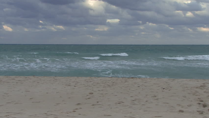 Male walking into ocean in suit