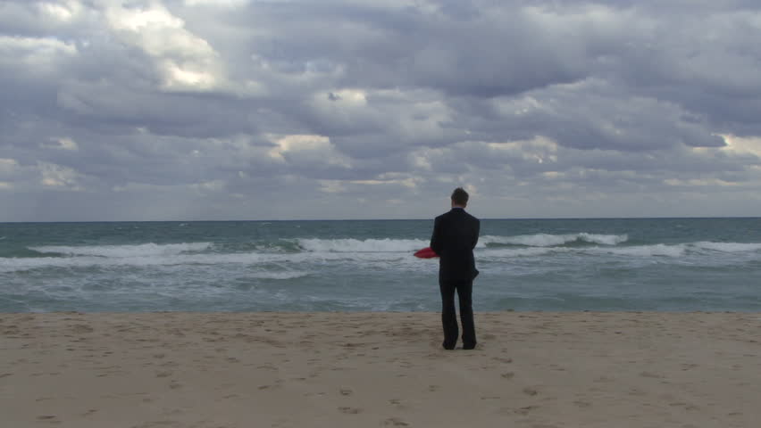 Male opening an umbrella on a beach