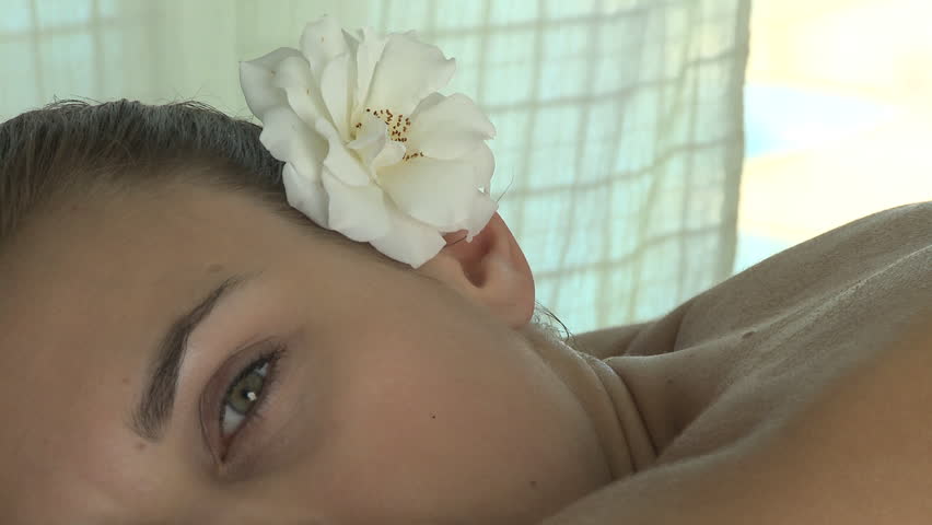 CLOSE UP PAN OF A YOUNG WOMAN HAVING A MASSAGE