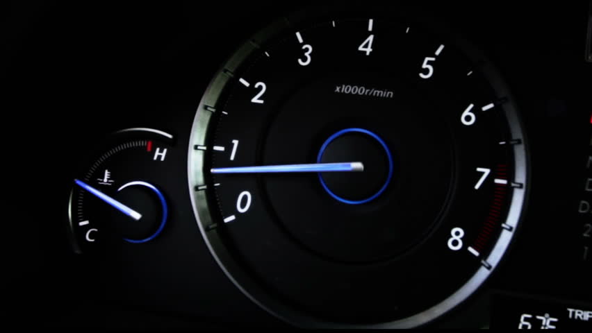 Car speedometer and tachometer, timelapse driving down road.