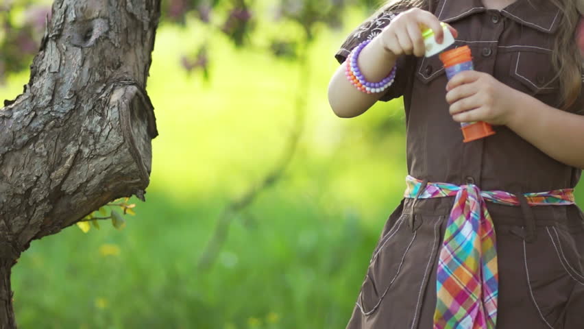 Laughing girl blowing bubbles