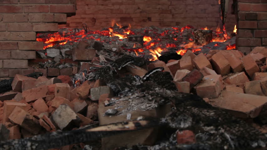 House burning through collapsed wall after roof collapse with old adobe bricks walls