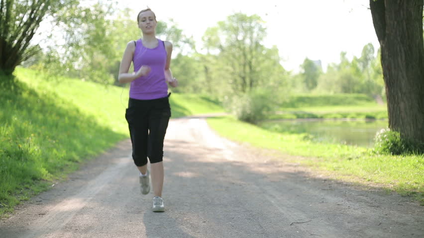 Young blond woman taking breath after jogging