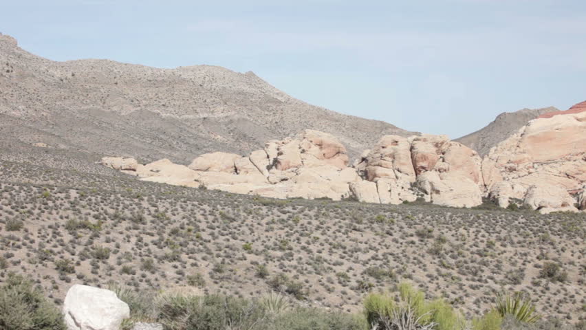 Desert scene scrub and shrub cactus against Calico Mountain in Red Rock Conservation area north of Las Vegas Nevada.  Decorative and mysterious sandstone formations in the desert. National park.