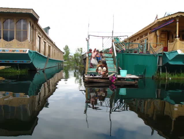 SRINAGAR, INDIA - APRIL 14: Kashmiri girl washing her clothes from houseboat on the waterfront on April 14, 2012 in Dal Lake, Srinagar, Jammu and Kashmir, India.
