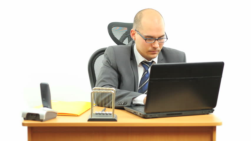 Young executive in grey business suit arguing over the telephone while sitting behind a laptop