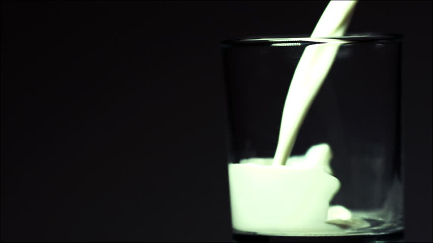 Milk is poured into a glass in slow motion