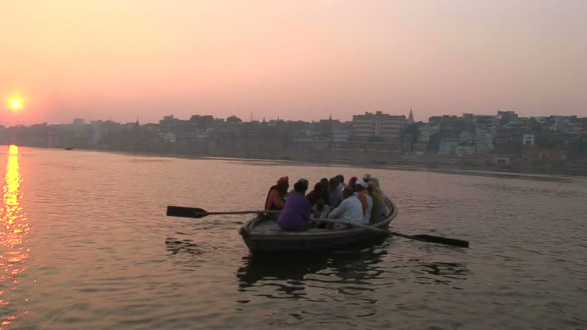 Pilgrim boat arriving at east Ganges bank with setting sun behind.Circa November, 2008, Veranasi, India
