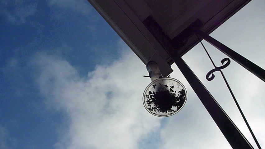 Cloud and blue sky time lapse with edge of front porch to house with bird feeder.