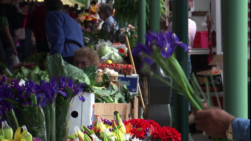 WASHINGTON DC - CIRCA MAY 2005: Flower arrangement in progress, moves back to wider shot of shoppers and stands in eastern market.