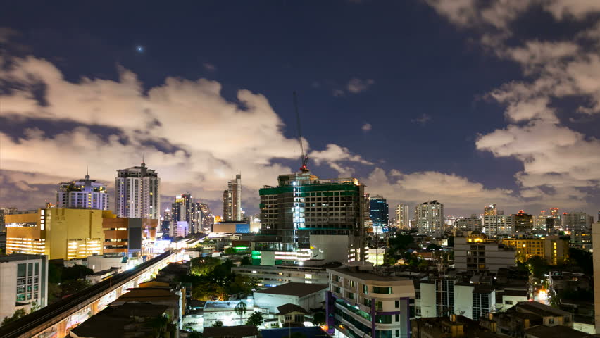 City at night with cloudscape under moonlight - Zooming effect with panning on the right 