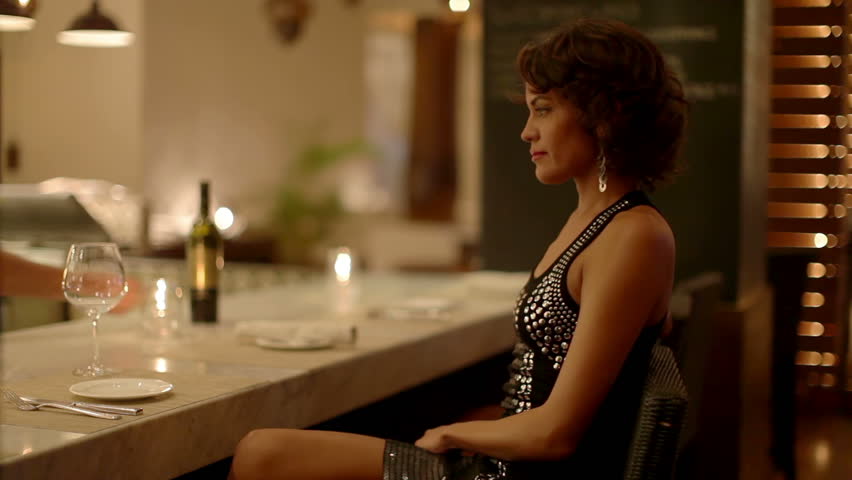 beautiful sexy woman drinks wine in a hotel bar at night