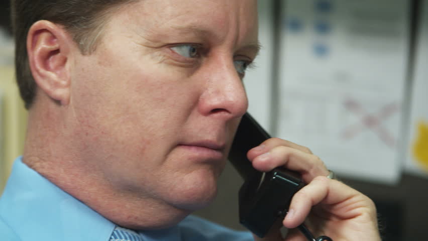 office worker listens intently to telephone call while swiveling chair