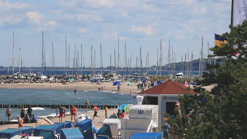 View of the marina of Kuehlungsborn with many people there have fun on the beach of the german baltic sea