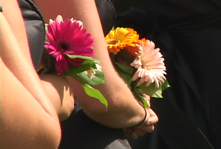 Bridal party stand with flowers at wedding ceremony.